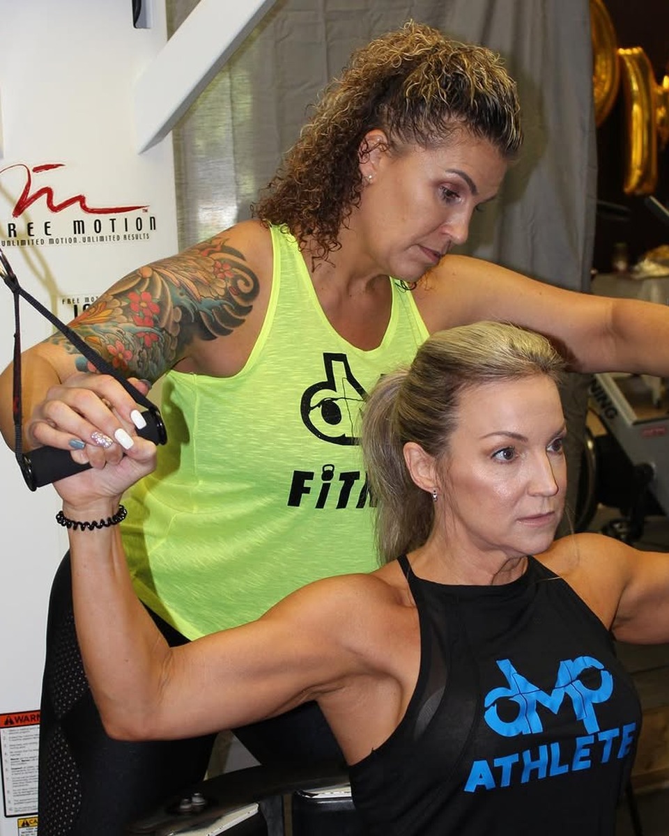 Dulcie Palmer coaching a client through an upper-body strength exercise