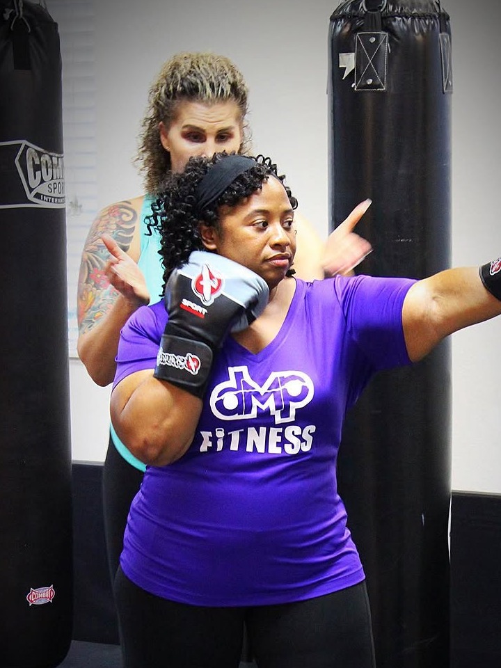 DMP Fitness boxing client practicing punches with Dulcie coaching nearby